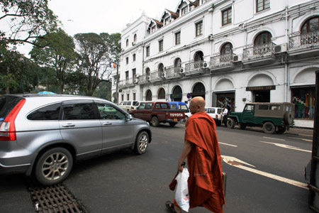Un monaco buddista vicino al Queen's Hotel immerso nel traffico. Antico e moderno a Sry lanka si mescolano continuamente.