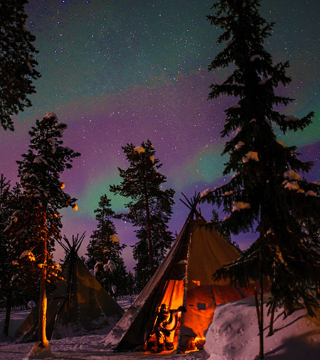 Northern Lights above tents at the reindeer lodge in Jukkasjärv